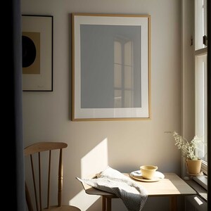 Könnte beinhalten: Ein Holztisch mit einer weißen Stoffserviette, einer gelben Keramiktasse und einer weißen Untertasse. Der Tisch steht in einem Raum mit einem Fenster und einem gerahmten Bild an der Wand.