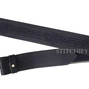 Pode incluir: Cinto de couro preto com n&oacute;s celtas e fivela. O cinto apresenta desenhos de n&oacute;s em relevo e uma fivela simples. A palavra "STITCHIFY" est&aacute; impressa no cinto. Um acess&oacute;rio elegante.