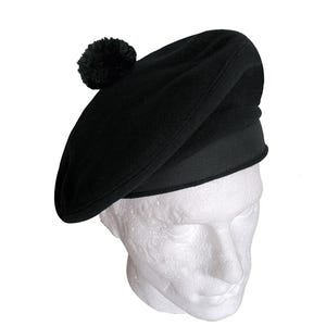 May include: A black beret with a black pom-pom on top. The beret is made of a soft, wool-like material.