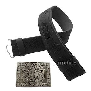 Pode incluir: Cinto de couro preto com design de n&oacute;s celtas e fivela prateada. O cinto apresenta padr&otilde;es em relevo e uma fivela retangular com intrincados desenhos de n&oacute;s. O cinto tem aproximadamente 102 cm de comprimento.