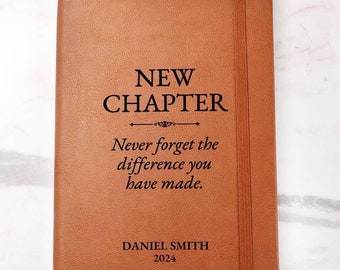 May include: A brown leather-bound journal with the words "NEW CHAPTER" printed in black. Below the title is the quote, "Never forget the difference you have made." The name "DANIEL SMITH" and the year "2024" are printed at the bottom.