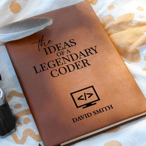 May include: A brown leather notebook with the text "the IDEAS OF A LEGENDARY CODER" and a computer screen icon. The name "DAVID SMITH" is printed at the bottom. A feather rests on the notebook.