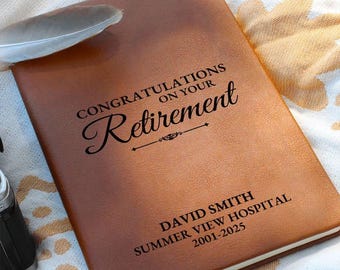 May include: Brown leather journal with the text "CONGRATULATIONS ON YOUR RETIREMENT" and a decorative line below. The text "DAVID SMITH SUMMER VIEW HOSPITAL 2001-2025" is also engraved on the journal.