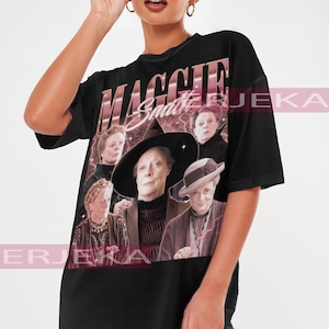May include: Black oversized t-shirt featuring a graphic of Maggie Smith with the text "MAGGIE Smith". The design includes multiple images of the actress. The shirt is a unisex style.
