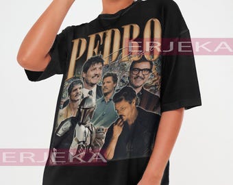May include: Black oversized t-shirt featuring a collage of images of Pedro Pascal, with the name "PEDRO" in gold lettering. The shirt has a vintage style and is worn by a person.
