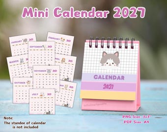 May include: A 2027 mini desk calendar with a spiral binding and a pink stand. The cover features a grid pattern and a cat illustration with the text "CALENDAR 2027". Several individual monthly pages are displayed, each showing cat graphics.