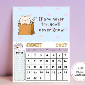 May include: A calendar page for August 2027 featuring a light blue background with pink hearts. A cartoon cat sits in a brown paper bag with the text, If you never try, you'll never know. Includes a notes section and a grid for the month of August.