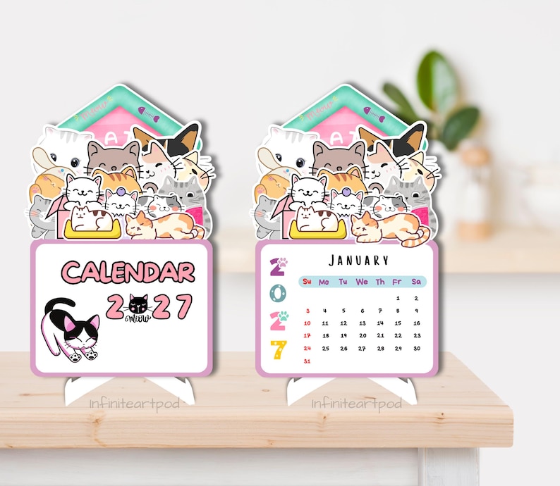 May include: Two standing desk calendars for 2027 featuring a group of illustrated cats at the top. The left calendar displays the text CALENDAR 2027 with a black and white cat. The right calendar shows the month of January with a grid of dates.