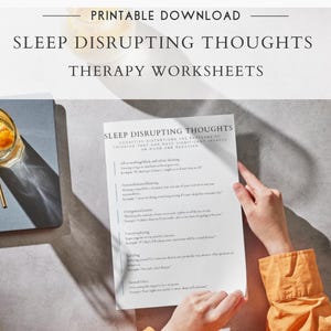 May include: A printable download titled "Sleep Disrupting Thoughts Therapy Worksheets." The image shows a person holding a worksheet with text about sleep. A glass of orange-infused drink and a notebook are also visible.