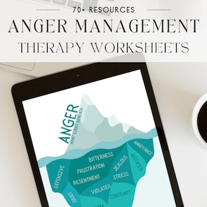 May include: A digital tablet displaying a graphic of an iceberg with the word "ANGER" written on the visible portion of the iceberg. The iceberg is labeled with words like "bitterness", "frustration", "resentment", "jealous", "stress", "violated", "contempt", "annoyance", and "agitated". The text "What lurks beneath" is written on the side of the iceberg. The tablet is on a white surface with a cup of coffee.