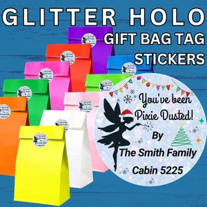May include: A collection of colorful paper gift bags in yellow, orange, green, pink, white, and purple, each featuring a round glitter holographic sticker. The sticker displays a black fairy silhouette, a Christmas tree, and the text You've been Pixie Dusted! By The Smith Family Cabin 5225.