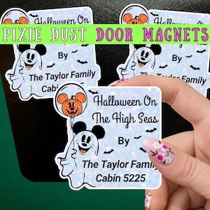 May include: A square-shaped magnet with a holographic finish featuring a cartoon ghost with mouse ears holding an orange pumpkin balloon. The text reads Halloween On The High Seas By The Taylor Family Cabin 5225, accented with small black bats.