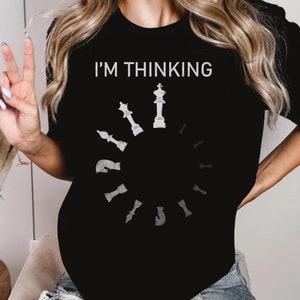 May include: Black t-shirt with a white graphic of a chessboard with the text "I'M THINKING" above it.