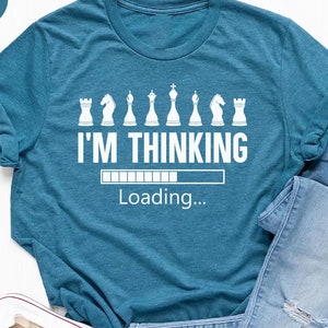 May include: A teal blue t-shirt with a white graphic of chess pieces and the text "I'M THINKING" with a progress bar that says "Loading..."