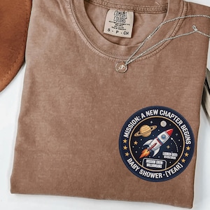 Camiseta Comfort Colors® personalizada para baby shower con temática espacial, parche de la misión de la NASA "Comienza un nuevo capítulo", regalo retro para mamá primeriza, camiseta para anunciar el embarazo.
