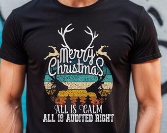 May include: Black t-shirt with a vintage Christmas design. The design includes the text "Merry Christmas" above a circular graphic with reindeer silhouettes and the phrases "All is Calm" and "All is Audited Right."