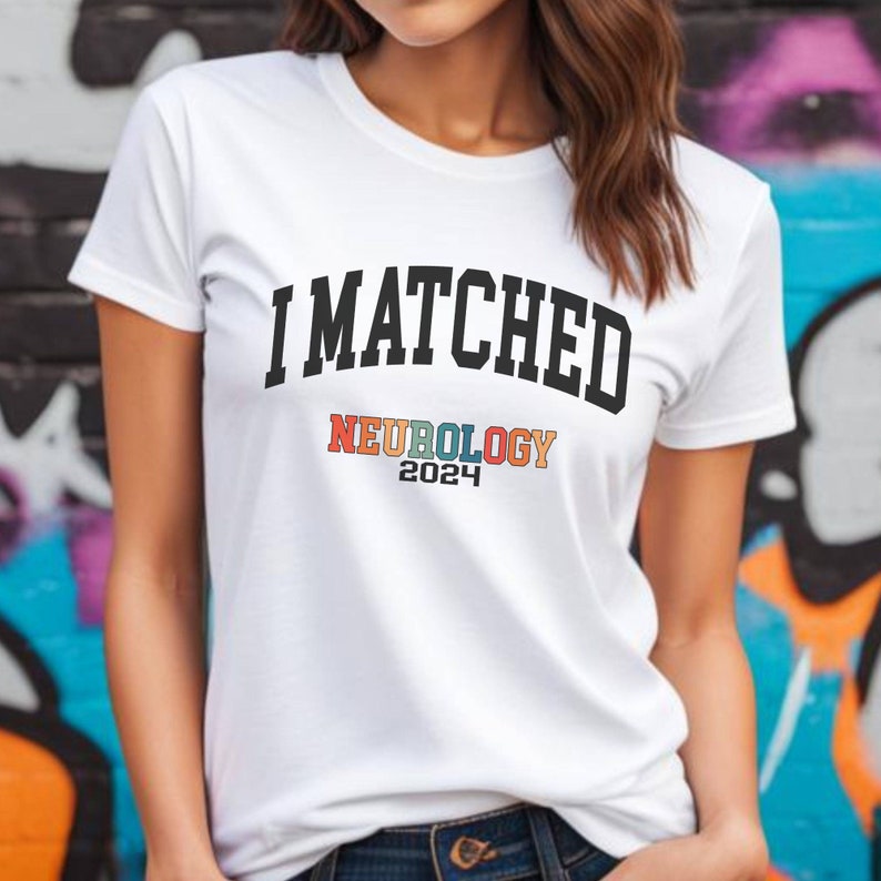 May include: White t-shirt with the text "I MATCHED" in black, and "NEUROLOGY 2024" in rainbow colours.