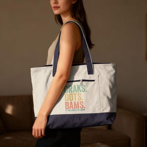 Tote bag with "BRAKS. DOTS. BAMS. IF YOU KNOW, YOU KNOW!" text.