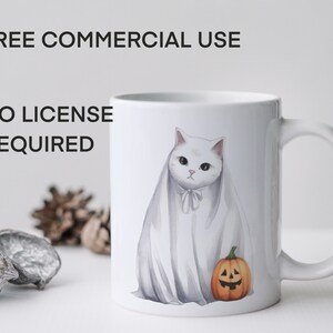 May include: White ceramic mug with a white cat wearing a ghost costume and holding a small orange pumpkin with a jack-o'-lantern face. The mug has the text "FREE COMMERCIAL USE NO LICENSE REQUIRED" printed on the side.