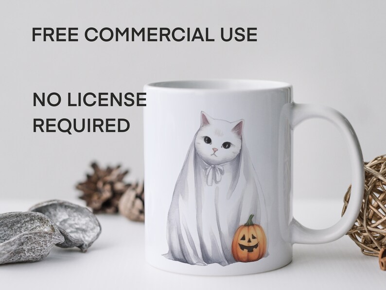 May include: White ceramic mug with a white cat wearing a ghost costume and holding a small orange pumpkin with a jack-o'-lantern face. The mug has the text "FREE COMMERCIAL USE NO LICENSE REQUIRED" printed on the side.