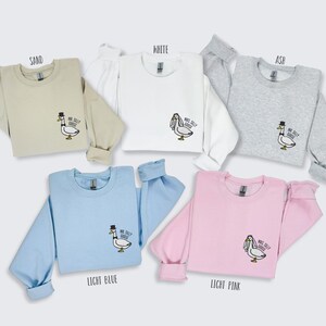 May include: Six sweatshirts in different colors, including sand, white, ash, light blue, and light pink. Each sweatshirt features an embroidered goose with the text "Mr. Silly Goose" or "Mrs. Silly Goose".