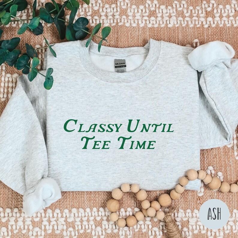 以下が含まれることがあります： 緑色の文字で「Classy Until Tee Time」と書かれた灰色のスウェットシャツです。