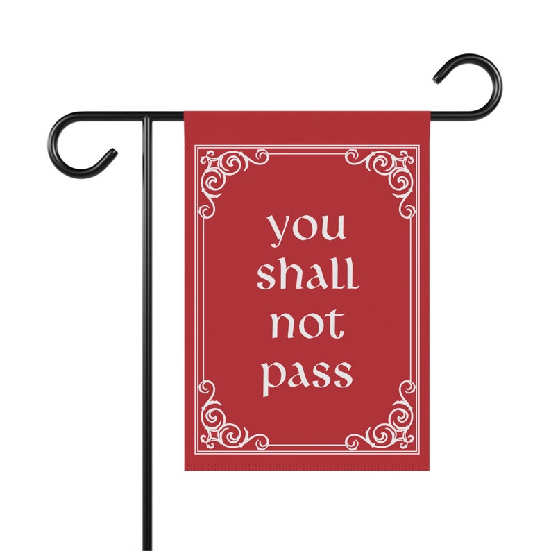 May include: Red garden flag with a white ornate frame and the text "you shall not pass" in white.