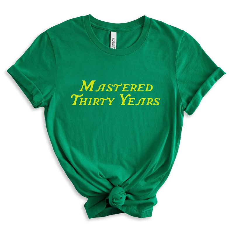 May include: Green t-shirt with yellow text that reads "Mastered Thirty Years".