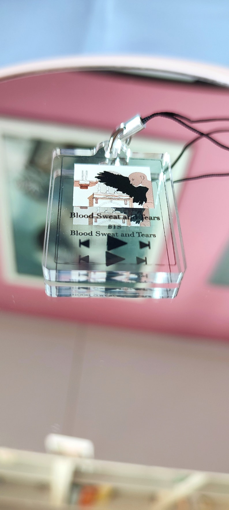 May include: A clear acrylic keychain with a black and white image of a bird with wings spread. The text "Blood Sweat and Tears BTS Blood Sweat and Tears" is printed on the keychain.