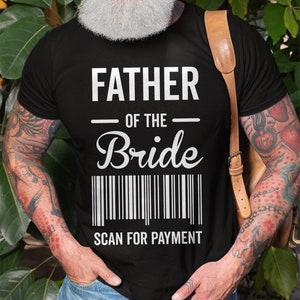 以下が含まれることがあります： 白い文字で「Father of the Bride」と書かれた黒いTシャツ。テキストの下にはバーコードがあり、その下に「Scan for Payment」という文字があります。