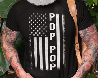May include: A black t-shirt with a white distressed American flag design and the word "POP" vertically down the right side of the flag.