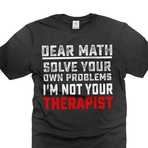Op de afbeelding: Zwart T-shirt met witte tekst die "Dear Math Solve Your Own Problems I'm Not Your Therapist" in rood zegt.