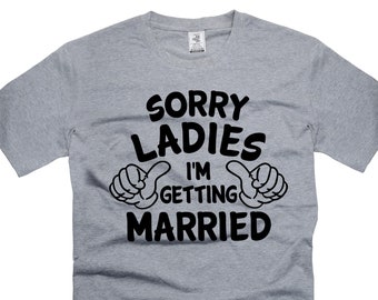May include: Gray t-shirt with black text that reads "Sorry Ladies I'm Getting Married" with two thumbs up on either side of the text.