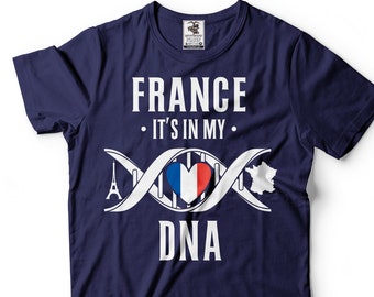 Puede incluir: Camiseta azul marino con texto blanco que dice "FRANCE - IT'S IN MY DNA" con un gráfico de una cadena de ADN con un corazón en el medio que tiene los colores de la bandera francesa. La Torre Eiffel está en un extremo de la cadena de ADN y el contorno de Francia está en el otro extremo.