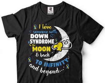 Può includere: Maglietta nera con una luna crescente bianca e un cuore giallo. Il testo dice "& Amo qualcuno con la SINDROME DI DOWN fino alla LUNA e ritorno ALL'INFINITO e oltre..."