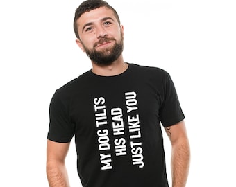 May include: A black t-shirt with white text that reads "My dog tilts his head just like you".