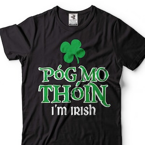 May include: Black t-shirt with a green shamrock and the text "Póg Mo Thóin I'm Irish" in white.