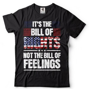 May include: Black t-shirt with a distressed graphic design featuring the American flag and the text "It's the Bill of Rights Not the Bill of Feelings".