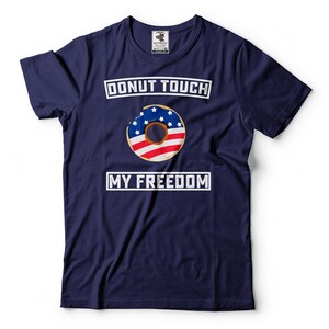May include: A navy blue t-shirt with a white graphic of a donut with the American flag design. The text "DONUT TOUCH MY FREEDOM" is printed in white on the shirt.
