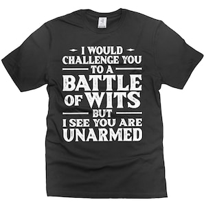 May include: Black t-shirt with white text that reads: "I WOULD CHALLENGE YOU TO A BATTLE OF WITS BUT I SEE YOU ARE UNARMED." The text is centered on the shirt.
