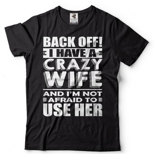 May include: Black t-shirt with white text that reads "Back off! I have a crazy wife and I'm not afraid to use her."