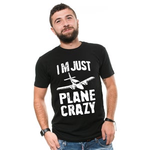 May include: A black t-shirt with a white graphic of a small airplane and the text "I'M JUST PLANE CRAZY".