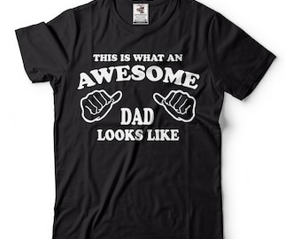 May include: Black t-shirt with white text that reads "This is what an awesome dad looks like" with two white thumbs up symbols on either side of the word "dad".
