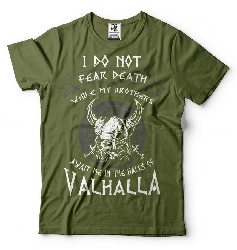 Puede incluir: Camiseta verde con un estampado gr&aacute;fico blanco de un guerrero vikingo con un casco con cuernos y empu&ntilde;ando espadas. El texto dice "No temo la muerte mientras mis hermanos me esperan en las salas de Valhalla."