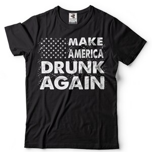Könnte beinhalten: Schwarzes T-Shirt mit einer weißen, abgenutzten Grafik, auf der "Make America Drunk Again" steht, mit einer stilisierten amerikanischen Flagge im Hintergrund.