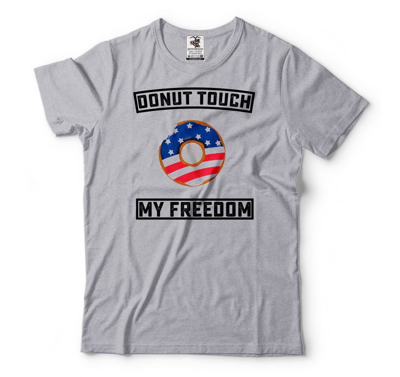 May include: Gray t-shirt with the text "Donut Touch My Freedom" in black. A donut with an American flag design is in the center of the shirt.