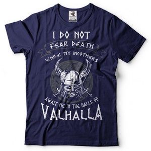 Puede incluir: Camiseta azul marino con un gr&aacute;fico blanco de un guerrero vikingo con el texto "No temo la muerte mientras mis hermanos me esperan en las salas de Valhalla".