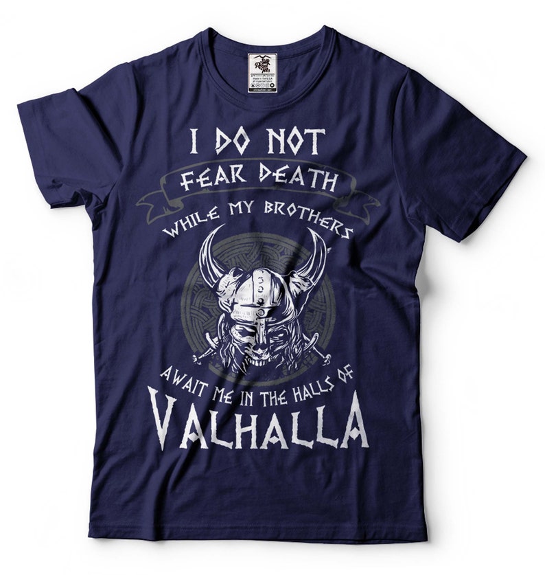 Puede incluir: Camiseta azul marino con un gr&aacute;fico blanco de un guerrero vikingo con el texto "No temo la muerte mientras mis hermanos me esperan en las salas de Valhalla".