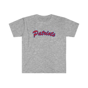 May include: A gray t-shirt with the word "Patriots" in red and blue lettering.