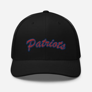 Może przedstawiać: Czarna czapka trucker z haftowanym logo "Patriots" w kolorze czerwonym i niebieskim.